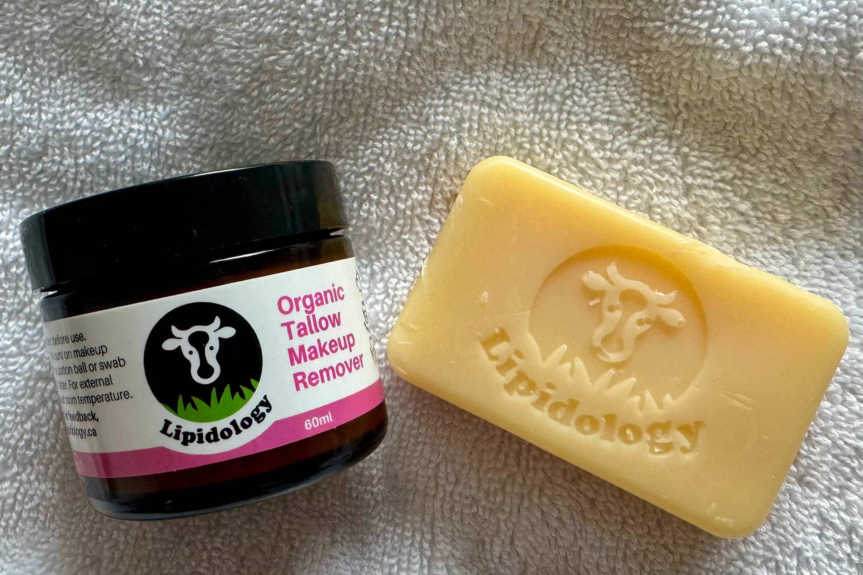 Lipidology Organic Tallow Makeup Remover jar and bar on a textured surface