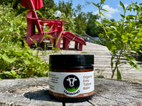 Jar of Lividology Organic Emu Tallow Balm on a wooden surface with a natural background